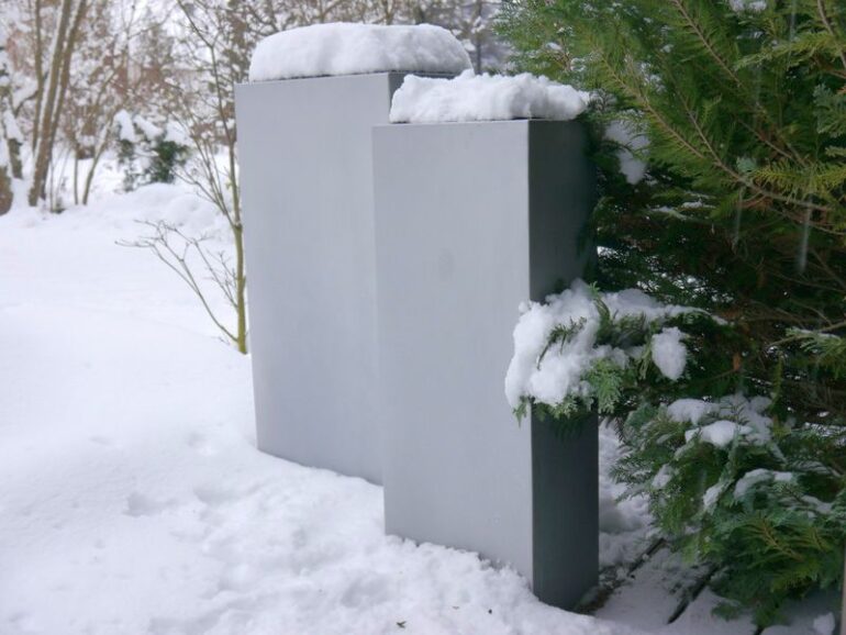 Schneebedeckte Pflanzkübel in einem Garten
